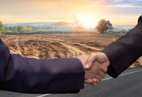 Business handshake land purchase. Building land for new construction project on green meadow, plot for construction area.  real estate sale or property investment concept, Buying new home for family.