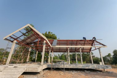 Çatı onarımı, inşaat işçisi yeni çatı döşeme aletleri, çatı matkabı, yeni çatıda metal levha ile kullanılan matkap. Çatı tamircisi, çatıda duruyor ve üstünü metalle örtüyor..