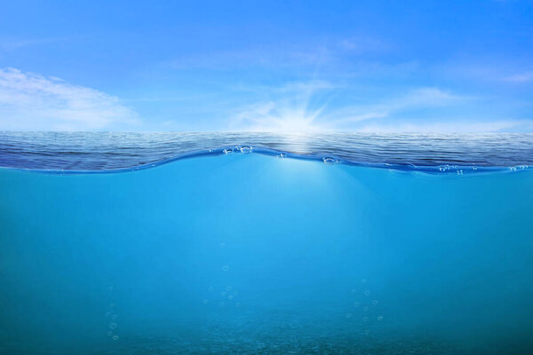 Волны и пузыри синей воды. Белые облака на голубом небе над спокойным морем с солнечным светом, спокойная морская гармония спокойной водной поверхности. Солнечное небо и спокойный голубой океан. 