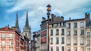 Bayonne Bask 'ta, tipik bir ön cephe, tarihi merkezde renkli panjurlar, arka planda Sainte-Marie katedrali.