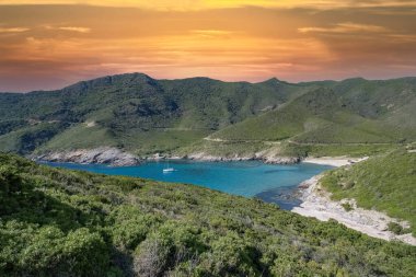 Korsika, şapkada deniz manzarası, kayıklı güzel bir dere, şeffaf su, yazın gün batımı.