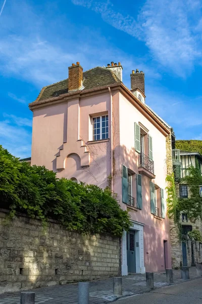 Paris, France, famous pink house in Montmartre, in a typical street