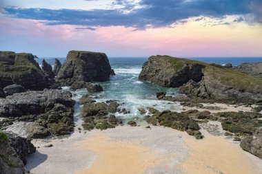 Brittany 'de Belle-Ile, Cote Sauvage' da kayalar ve kayalıklarla kaplı deniz manzarası.