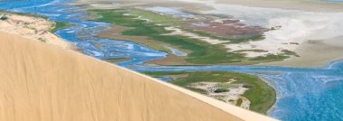 Namibya, Namib Çölü, denize düşen sarı kum tepelerinin manzarası.