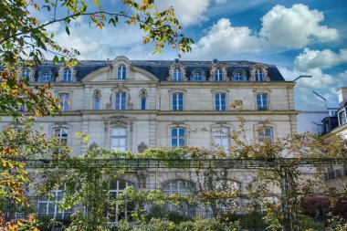 Paris, Saint-Gilles Meydanı, arka planda tipik binaları olan, üç katlı bir halk bahçesi.