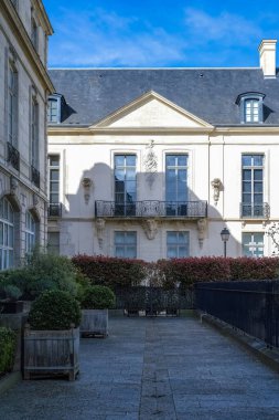 Paris, Saint-Gilles Meydanı, arka planda tipik binaları olan, üç katlı bir halk bahçesi.