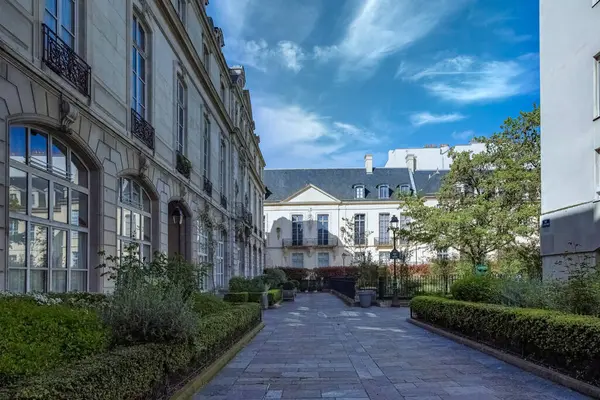 Paris, Saint-Gilles Meydanı, arka planda tipik binaları olan, üç katlı bir halk bahçesi.
