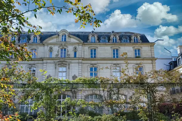 Paris, Saint-Gilles Meydanı, arka planda tipik binaları olan, üç katlı bir halk bahçesi.