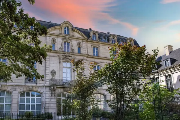 Paris, Saint-Gilles Meydanı, arka planda tipik binaları olan, üç katlı bir halk bahçesi.