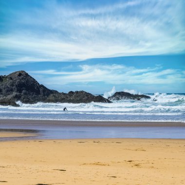 Brittany 'de Belle-Ile, Cote Sauvage' da bir plaj, bir sörfçüyle.