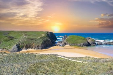 Brittany 'de Belle-Ile, Cote Sauvage' da bir sahil, kayalıkları ve kayaları olan, gün batımı.