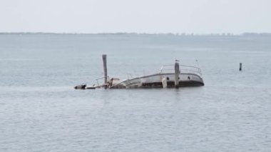 Batık tekne pruvası, deniz suyundan çıkmış sopalar.