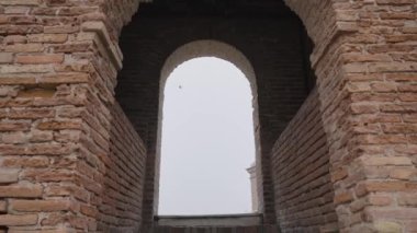 Door shaped opening under a tower going to the sky with flying birds.