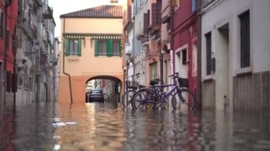 December 2021, Chioggia. Bicycles parked on the street flooded with water