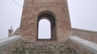 Arched entrance inside an ancient brick tower on the stairs