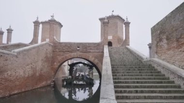 Christmas crib under the bridge in Comacchio, Italy in winter on a foggy day.