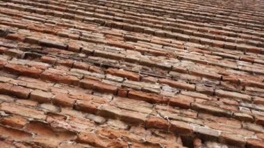 Şehir merkezinde, parlak güneş ışığı altında, alçak açılı, geniş, turuncu tuğla duvar duvar freski çatlakları var.