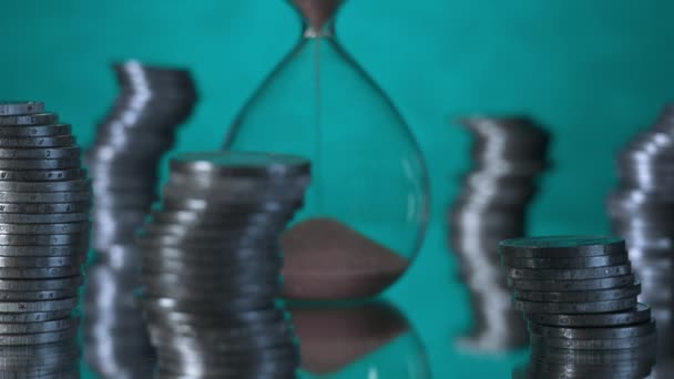 Sand Flows Hourglass Surrounded Stacks Coins — Stockvideo