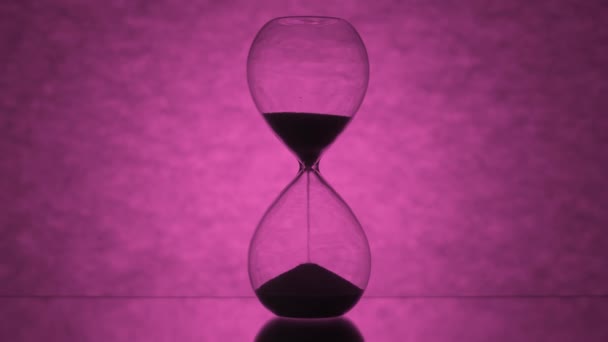 Glass Hourglass Flows Backlight Bright Pink Background — Stok video
