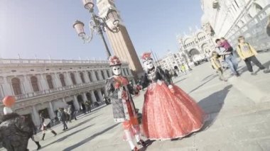 Venice, Italy - February 2023. People with ancient elegant clothes and venetian masks in San Marco square