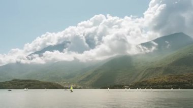 Como Gölü 'nün önündeki dağların panoramik manzarası ve zaman ayarlı yelkenliler.