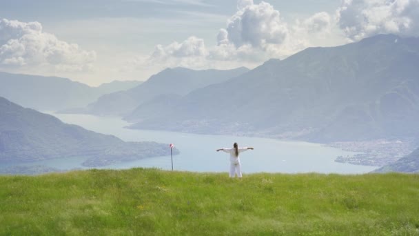 Mulher Vestida Vestido Verão Branco Sobre Grama Nas Montanhas Relaxante — Vídeo de Stock