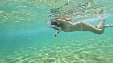 Küçük kız Akdeniz 'in sularında yüzerken maskeyle şnorkel kullanmayı öğreniyor..