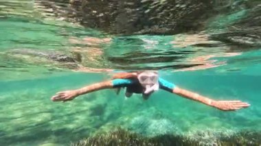 Snorkeler, İtalyan denizinin berrak sularında yüzer.