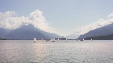 15 Ağustos 2023, Como Gölü, İtalya. Bir sürü yelkenli, dağların arasındaki gölde spor yapıyor.