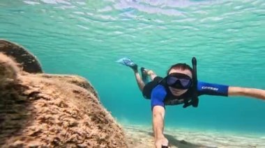 15 Ağustos 2023, Sardinya, Maddalena Adası. Dalgıç kıyafetli ve gözlüklü bir adam Sardunya 'da deniz tabanında yüzer.