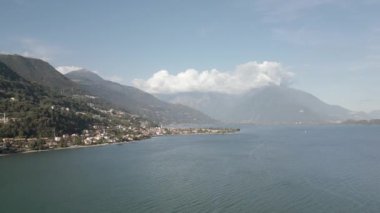 Como Gölü kıyısında yeşil dağların önünde bir şehir.