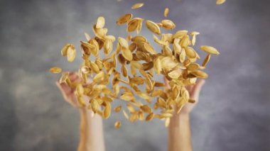 Eller yavaş çekimde kızartılmış kabak tohumlarını stüdyoya atıyor..