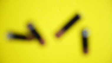 AA pilleri ağır çekimde sarı masaya düşer.