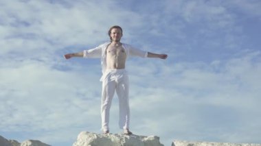 Adam kollarını rüzgara açıyor ve gülümseyerek odaya bakıyor..