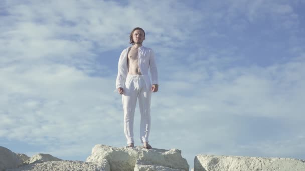 Człowiek Długimi Włosami Stojący Bez Butów Szczycie Skał Błękitnym Niebem — Wideo stockowe