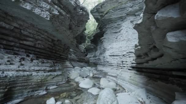 石の間に流れる水の流れの間の岩の間の狭い通路 — ストック動画