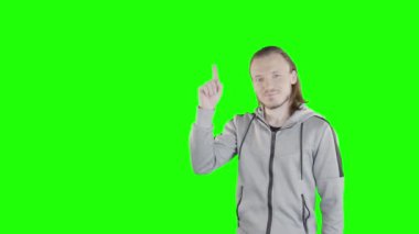 Adam elinde kroma anahtarı tekniği için yeşil ekrandaki şeylerin bir listesini gösteriyor. Yüzünde basit bir gülümseme ifadesi var..