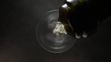 Kadehlere köpüklü şarap dökme hareketi. Yukarıdan Macro atışı. Kamera camın üstünden hareket ediyor ve içeri giriyor.. 