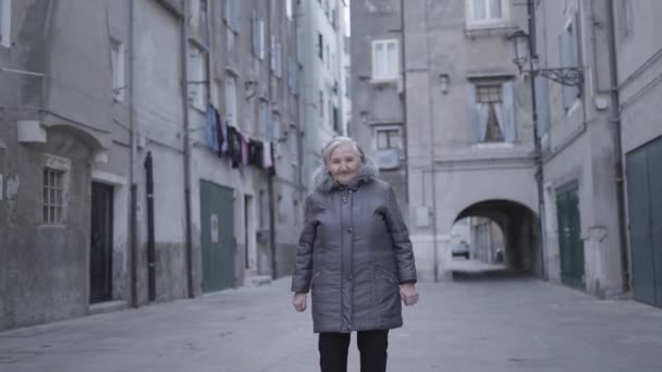 Een Oudere Vrouw Wandelt Door Een Steegje Tussen Twee Gebouwen — Stockvideo