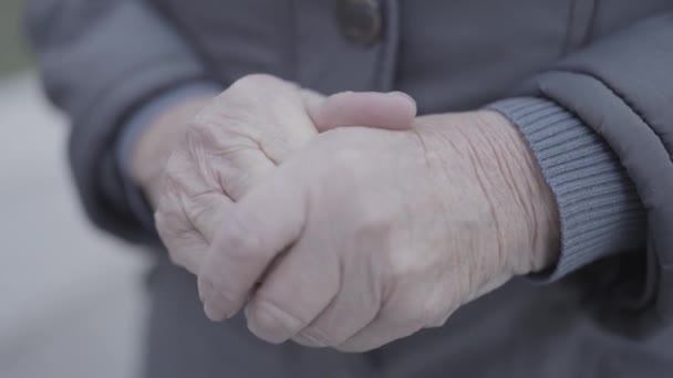 高齢の女性の手の近くには 礼拝で折られた手と 袖で組み立てられた穏やかな親指のジェスチャーがあります — ストック動画