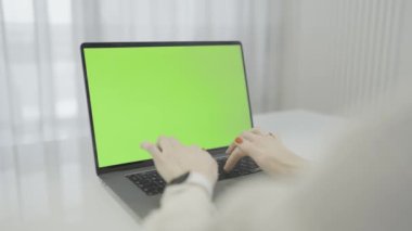 Bu kişi, kişisel bilgisayar olarak kullanılan elektronik bir cihaz olan yeşil ekranla dizüstü bilgisayarında yazıyor. Dizüstü bilgisayar, dikdörtgen biçimli çıkış aygıtı olan modern bir aygıttır.