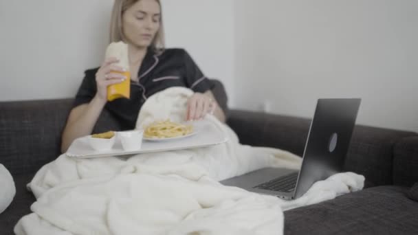 Жінка Сидить Дивані Ноутбуком Колінах Підносом Їжі Руці Рука Розтягується — стокове відео
