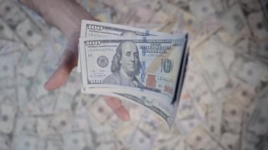 Ön planda bir adam var, yukarıdan vurulmuş, banknotları yavaş çekimde fırlatıyor..