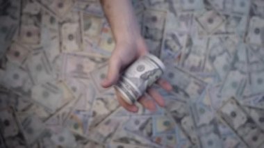 Dolar banknotları yavaş çekimde yükseğe fırlatılır. Yukarıdan vurulmuş. Arka planda dağınık banknotlar görebilirsiniz..