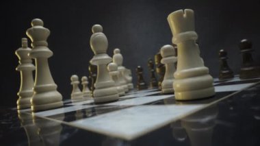 Satranç tahtasının yakın plan video çerçeveleri parçalara odaklanmış, dramatik bir oyun senaryosu çağrıştırıyor.