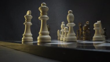 Yakın çekim bir resim dramatik, yoğun ışıklandırma bir satranç tahtasını aydınlatıyor, stratejik oyun oyununa odaklanmamızı sağlıyor