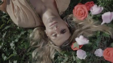 Huzurlu ve huzurlu bir insan portresi. Etrafı canlı ve renkli güllerle çevrili.