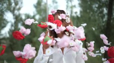 Bir kadın zarif bir şekilde şemsiyesini tutarken doğada canlı, renkli çiçeklerle çevrili.