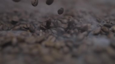 Dinamik ve büyüleyici bir çekim. Kavrulmuş kahve çekirdekleri. İçinden zarif bir buhar yükseliyor.
