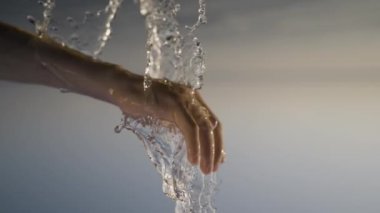 Huzurlu bir an, bir el zarif bir şekilde akan sudan çıkıyor, huzuru mükemmel bir şekilde yakalıyor.